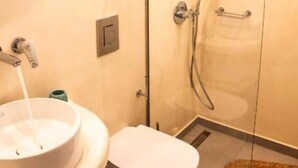 A bathroom with a toilet, sink, and shower. - Vista Al Mar (Santorini)