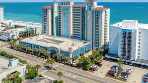 A high-rise hotel with a central courtyard, multiple balconies, and a view of the ocean. - Oceanfront one bedroom deluxe, sleeps up to 8 ppl 20+pools, lazy river,hot tubs (Myrtle Beach)