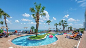 A pool area with palm trees, lounge chairs, and a view of the ocean. - Oceanfront one bedroom deluxe, sleeps up to 8 ppl 20+pools, lazy river,hot tubs (Myrtle Beach)