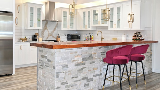 A modern kitchen with white cabinets, a stone island, and red bar stools. - Modern cozy home, pet friendly (Wolcott)