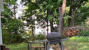 En terrasse med grill, bord og stol.