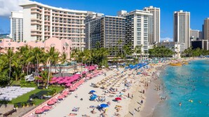A beach resort with multiple high-rise buildings, a sandy beach, and numerous umbrellas. - Waikiki studio, panoramic view, lots of amenities, 10 min walk to the beach! (Honolulu)