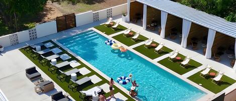 Una piscina al aire libre, camas de piscina con cargo