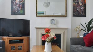 A living room with a flat-screen TV, a fireplace, and artwork on the walls. - 6 bedroom accommodation in Clacton on Sea (Clacton on Sea)