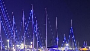 A marina at night with boats docked and illuminated by blue lights. - Amare Luxury Living Volos (Volos)