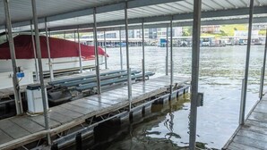 Un muelle cubierto con un bote, un amaradero pequeño y un canal de agua.