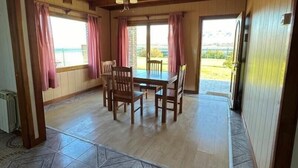 A dining area with a wooden ceiling and a view of the outdoors. - LA 48 (El calafate)