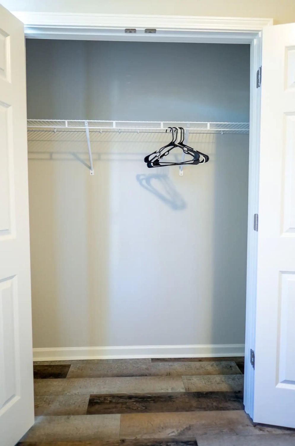 A closet with a hanging rod and a coat rack.