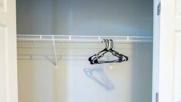 A closet with a hanging rod and a coat rack.
