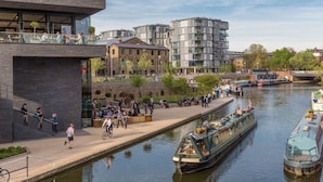 A riverside walkway with modern buildings, a canal with boats, and people walking and cycling. - The King's Cross Boutique Apartment!!! (London)