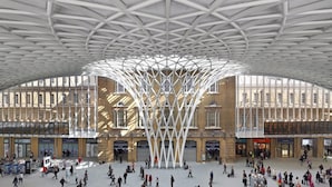 A spacious indoor area with a distinctive geometric ceiling structure, large windows, and a central open space surrounded by brick buildings. - The King's Cross Boutique Apartment!!! (London)