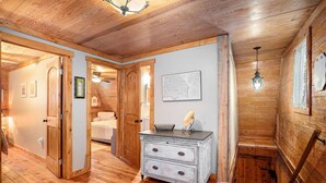 Un interior de madera con un aparador, un mapa en la pared y una escalera.