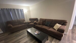 A living room with a sectional sofa, a coffee table, and a floor lamp.