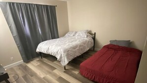 A small bedroom with a bed, a desk, and a chair.