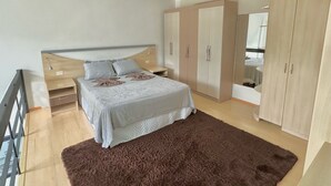 A bedroom with a bed, nightstands, a wardrobe, and a large mirror. - Saint Sebastian Flat 603Duplex no Centro (Jaragua do Sul)
