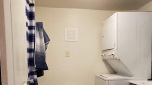 A laundry room with a washing machine, a dryer, and a small trash bin labeled 'WASH DRY'. - Private Studio whole unit (Rockford)