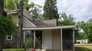 A single-story house with a covered porch, stone exterior, and a small front yard. - Private Studio whole unit (Rockford)