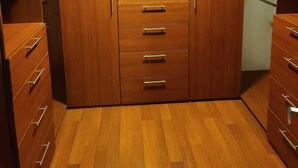 A wooden closet with multiple shelves and drawers.