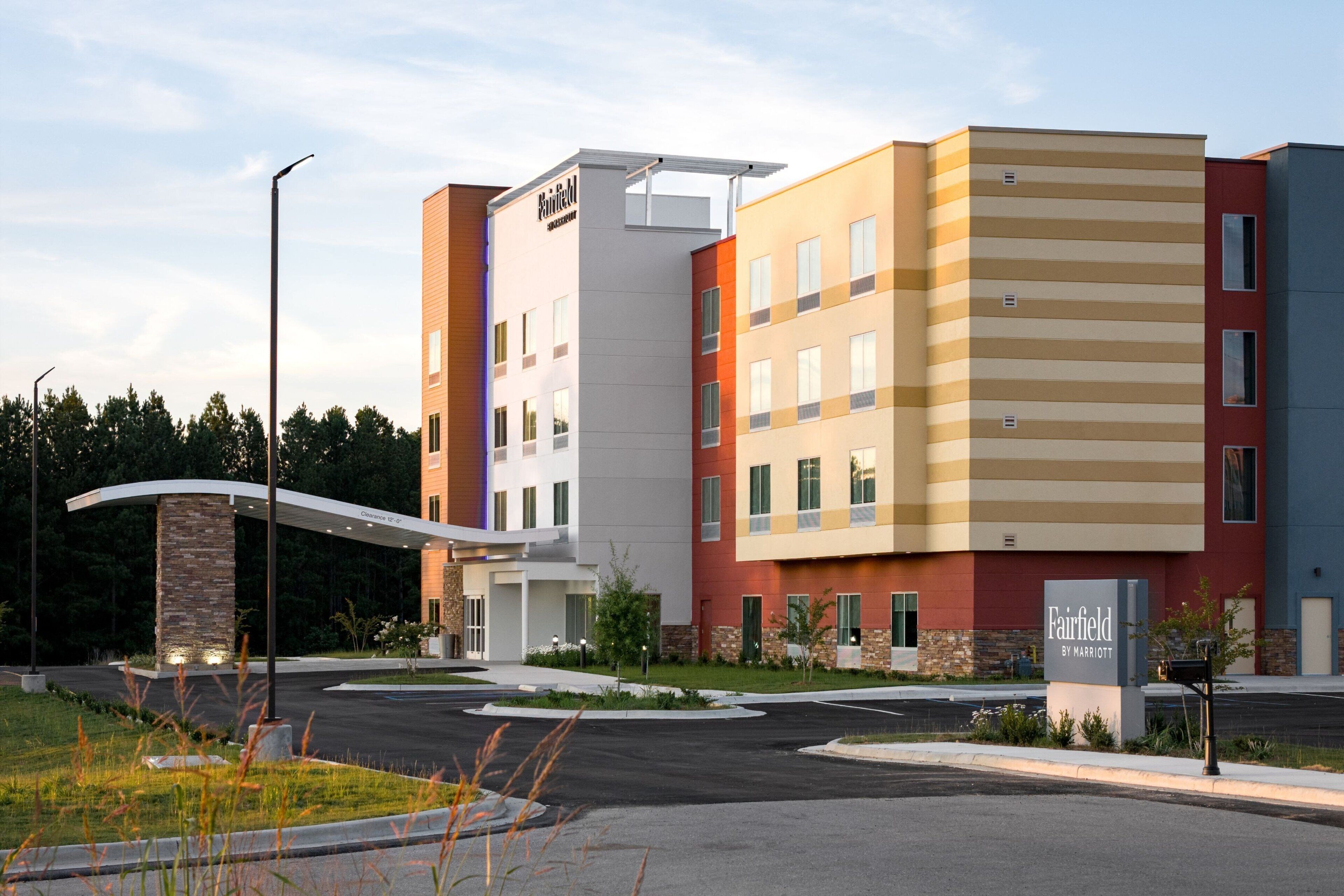 Modernilla designilla varustettu, useita kerroksia käsittävä Fairfield by Marriott -hotelli, jossa on yhdistelty punaisen, beigen ja valkoisen sävyjä, ja sen sisäänkäyntialue on maisemoitu.
