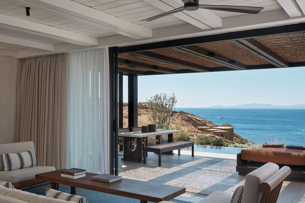 A modern living room with a large window overlooking a scenic coastal view.