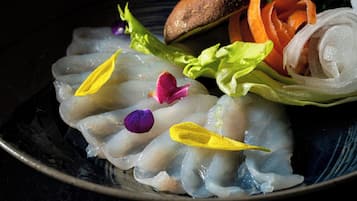 Un plato de sashimi con guarniciones y verduras.