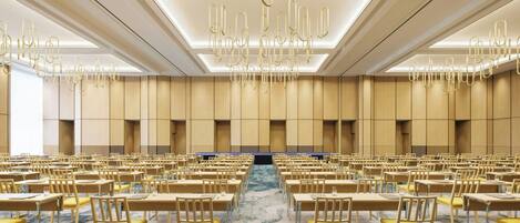 A conference room with rows of tables and chairs, a patterned carpet, and a modern ceiling design.
