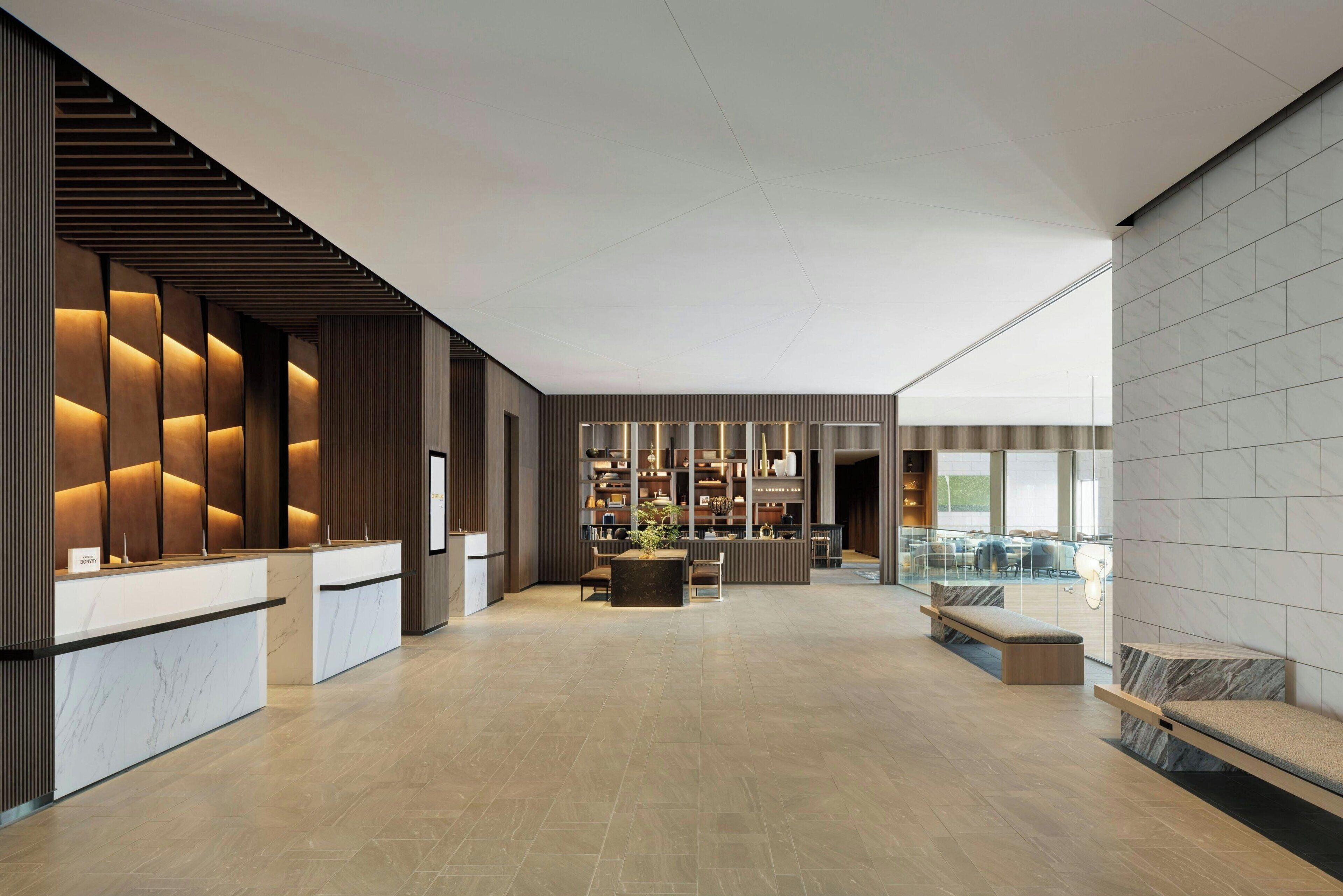 En moderne lobby med receptionsdisk, siddeområde og udsigt over indretningen.