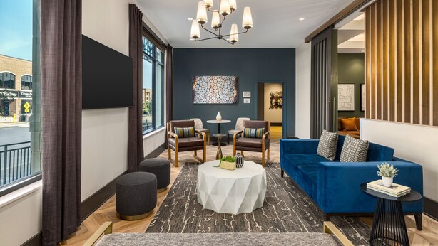 A modern hotel lobby with a blue sofa, two armchairs, a round coffee table, and a chandelier. - Towneplace Suites By Marriott Memphis Germantown (Germantown)