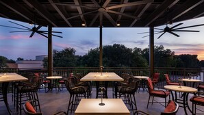 An outdoor patio area with tables and chairs, ceiling fans, and a view of the trees and sky. - Towneplace Suites By Marriott Memphis Germantown (Germantown)