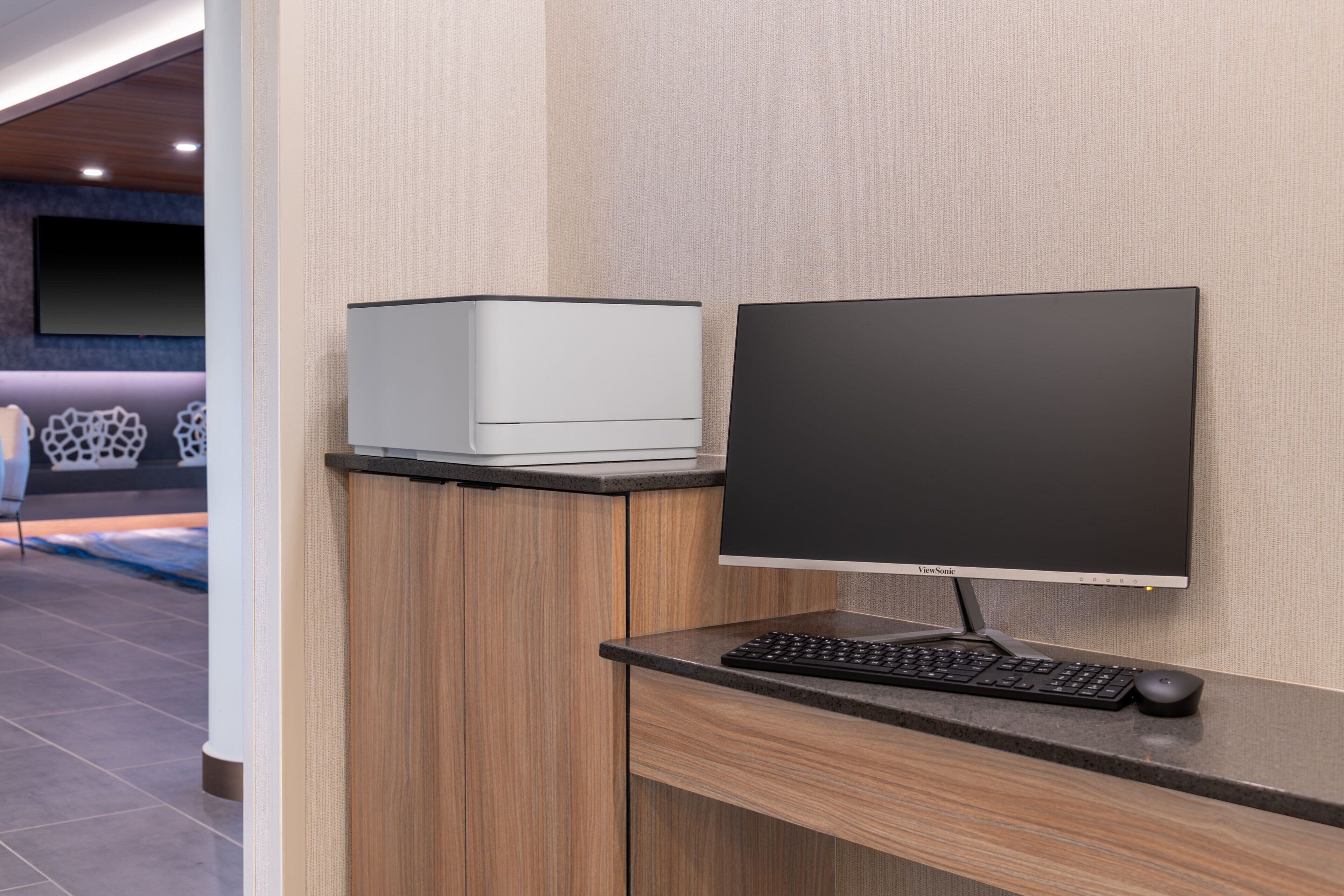 A modern office desk with a computer monitor, keyboard, and mouse.