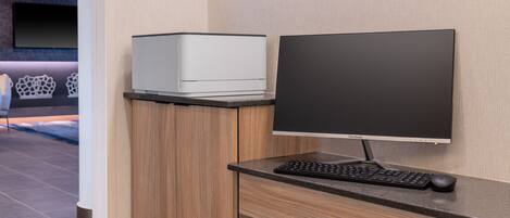 A modern office desk with a computer monitor, keyboard, and mouse.