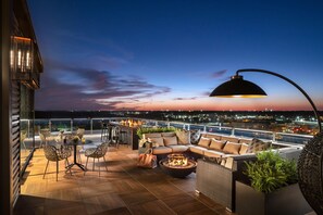 A rooftop terrace with a fire pit, outdoor seating, and a view of the city at dusk. - Moxy Springfield Downtown (Springfield)