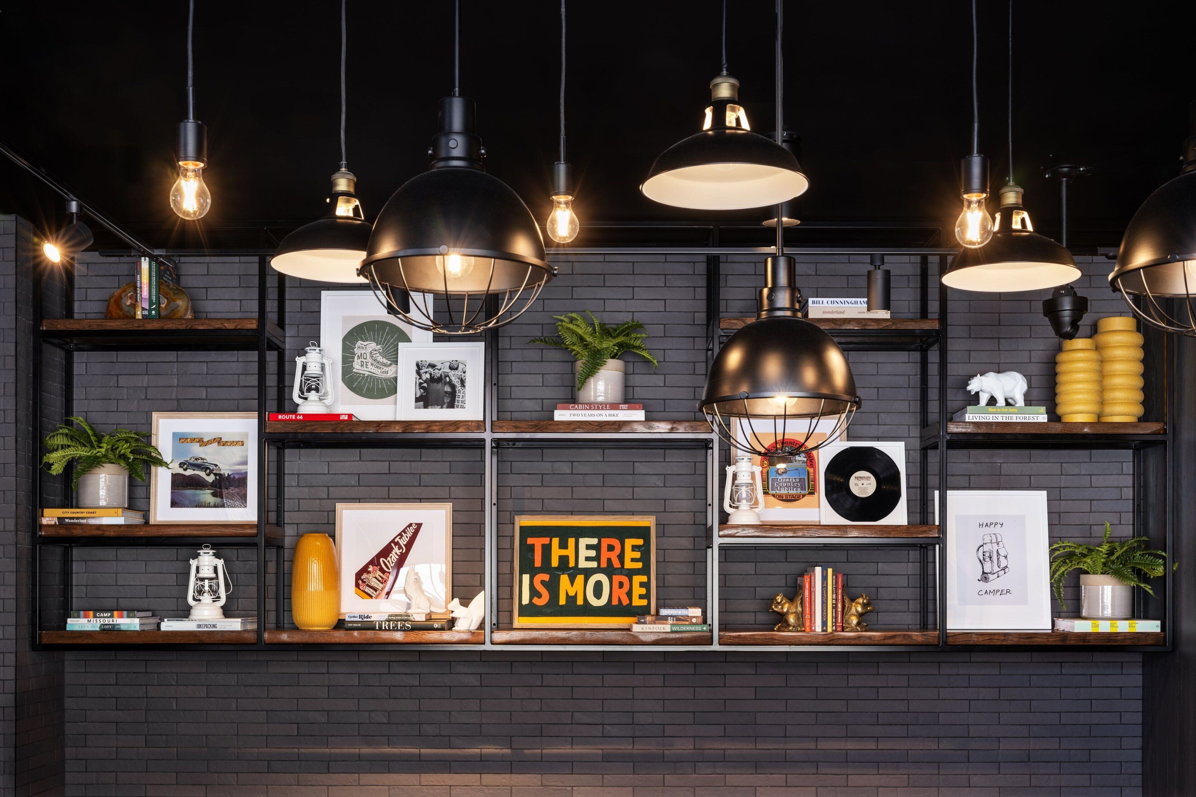 A wall with shelves displaying books, framed pictures, and decorative items.