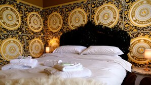 Ett hotellrum med en stor säng, vita sängkläder och en mjuk, vit matta.