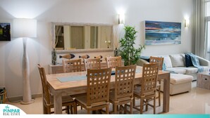 Et moderne spiseområde med et træbord og stole, en sofa og et billede på væggen.