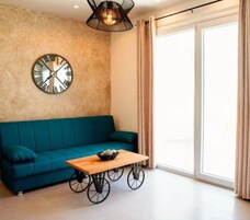 Una sala de estar moderna con un sofá color turquesa, una mesa de centro de madera y un reloj de pared.