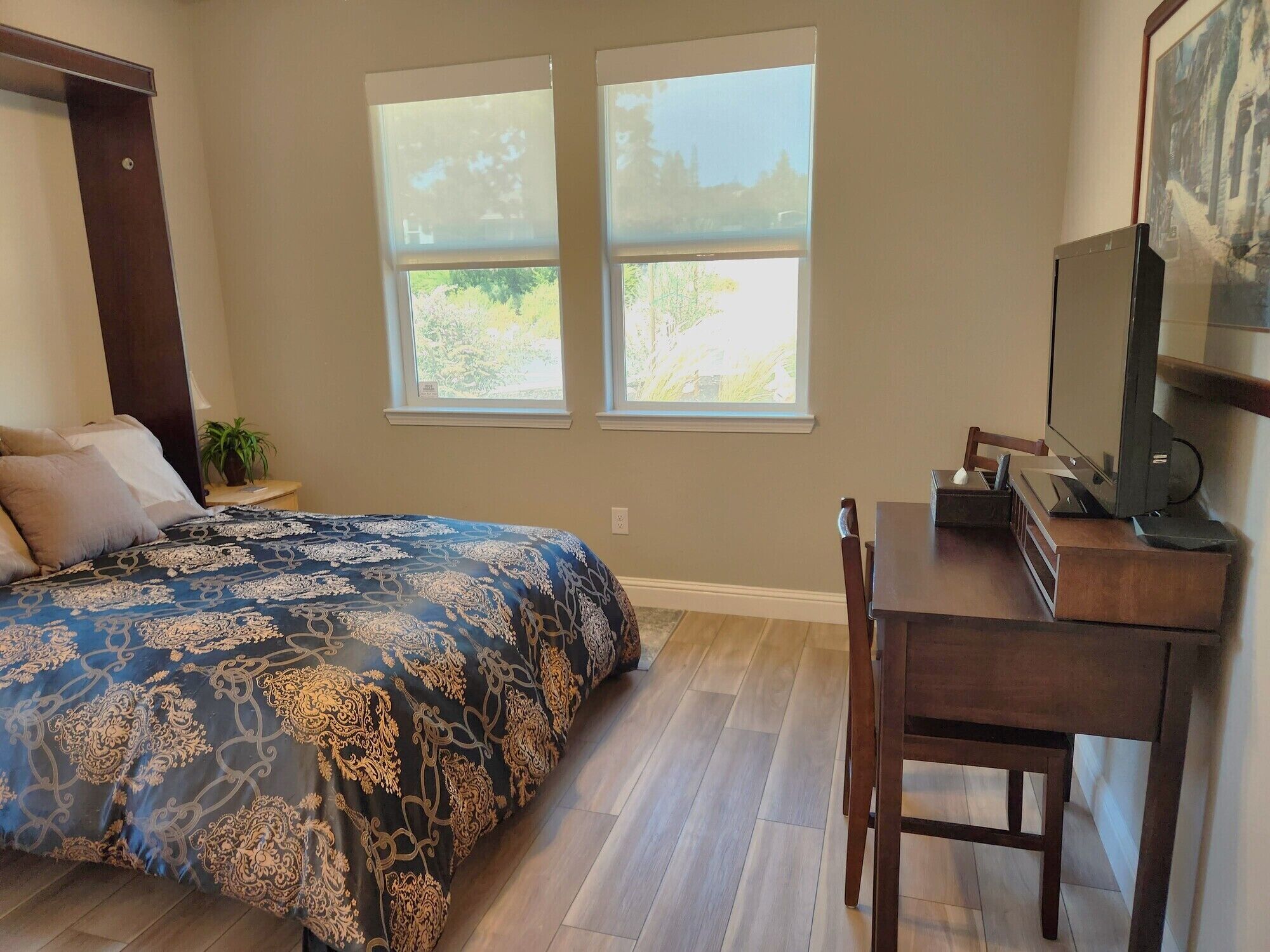 Une chambre à coucher avec un lit, un bureau et un téléviseur.