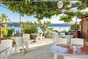 Relax in a serene outdoor space with a tranquil view of the lake, surrounded by lush greenery and comfortable seating.