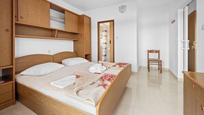 A bedroom with a wooden bed, a wooden wardrobe, and a chair. - Spectacular Sea View, Mooring - Jurica (Petra) (Rab)