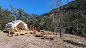 A small, rustic cabin with a wooden deck and a tent-like structure. - Glamping Tents 1, 2, 3 (Vanderpool)