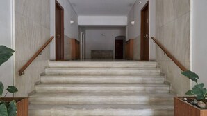A staircase with wooden handrails and marble steps leading to a landing. - Little Gem: Modern Urban Retreat (Athina)