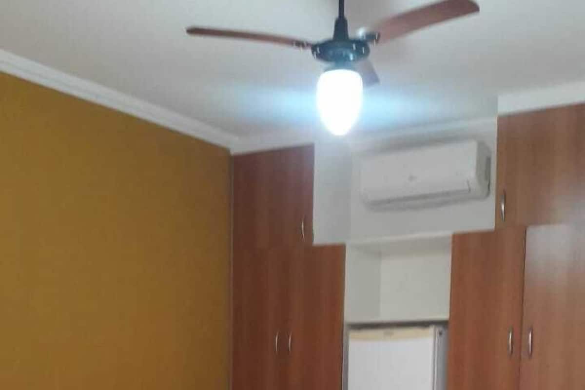 Ein Schlafzimmer mit Bett, Kleiderschrank, Deckenventilator und Klimaanlage.