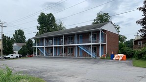 Ein zweistöckiges Motel mit einem Balkon und einer Treppe, die zum Obergeschoss führt.