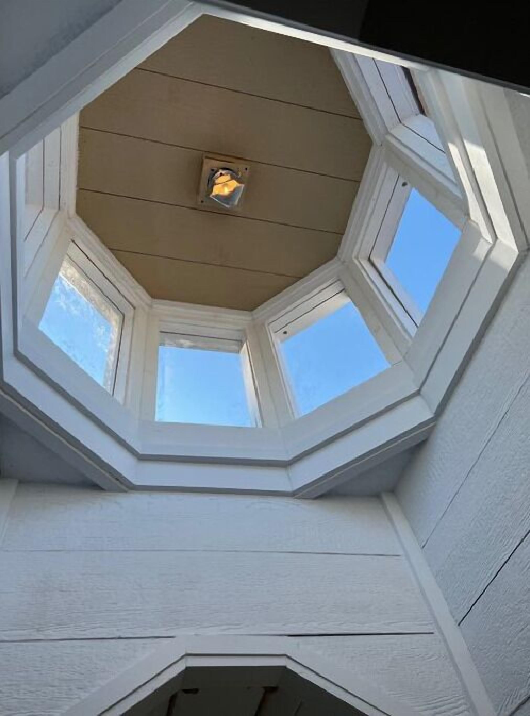 Una habitación con techo inclinado y tragaluces que permiten la entrada de luz natural.