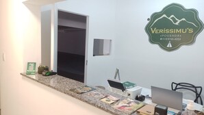 En reception med logo, en computer og forskellige genstande på disken.
