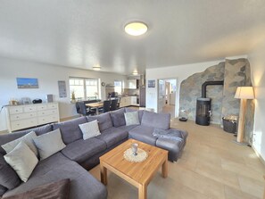 A modern living room with a sectional sofa, a wooden coffee table, and a stone fireplace.