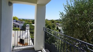 A balcony with a view of a residential area, a small garden, and a tree. - Tuscan Villa with a view. (Havelock North)