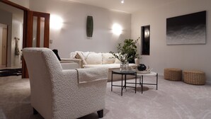 A modern living room with a plush sofa, a coffee table, and a large abstract painting on the wall. - Tuscan Villa with a view. (Havelock North)