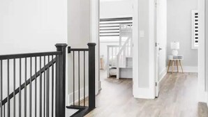 Ein modernes Interieur mit einer Treppe, weißen Wänden und einem Holzboden.