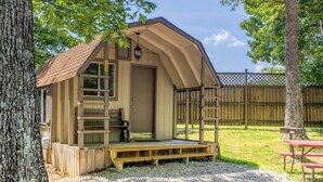 Eine kleine Holzhütte mit Veranda, einer Leiter und einem Picknicktisch.